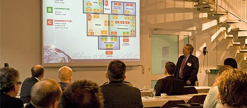 Mitarbeiter hölt eine Präsentation vor weiteren Menschen