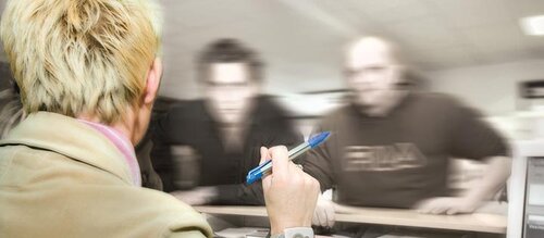 Frau an Empfang wird von zwei Männern angeschrien