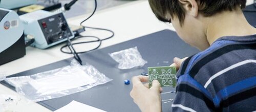 kleiner Junge hält kleines Gehäuse in der Hand