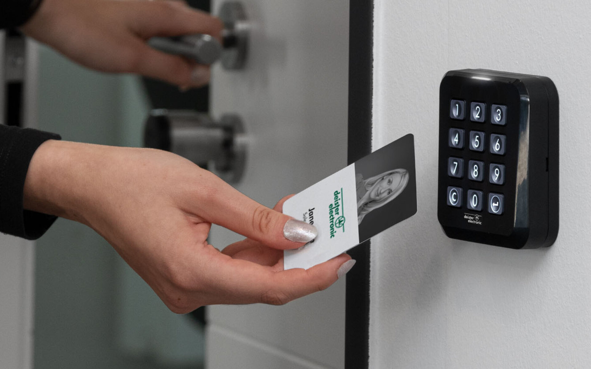 RFID-Karte wird vor schwarzen Zutrittsleser gehalten