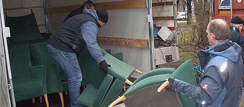 Männer beladen LKW mit Sessel