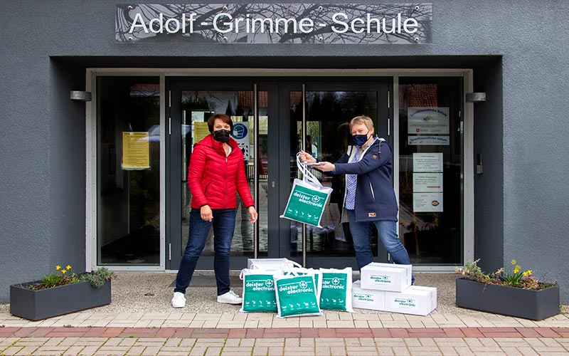 deister electronic übergibt Maskenspende an Adolf Grimme Schule vor dem Haupteingang der Schule